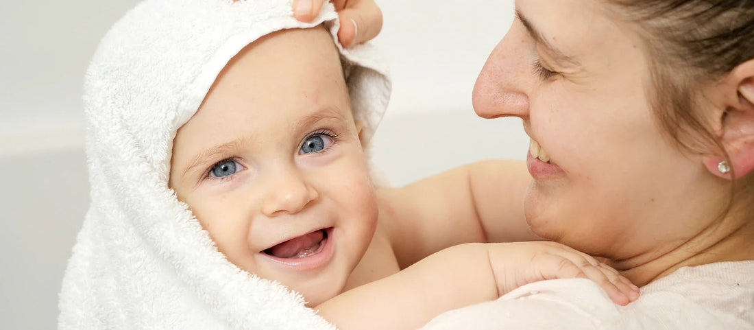 Douche sécurisée avec un guide pour bébé montrant la technique douce avec la douchette StoneStream
